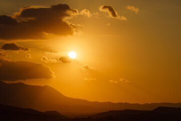 Sun goes down behind mountains -Sunset in hilly terrain