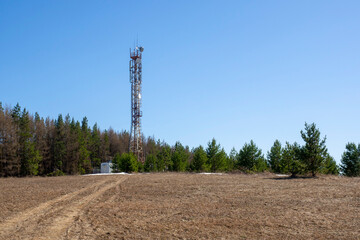 Telecommunications tower with 4g mobile communication antenna on top of a hill. Rural landscape.