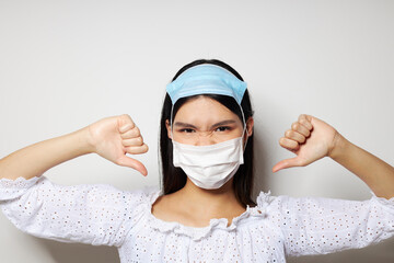 Charming young Asian woman medical mask protection light background unaltered