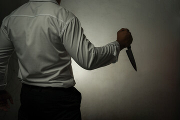 A criminal businessman wearing a white long-sleeved shirt holding a bloody knife is brutally...