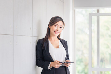 Young business woman using a tablet PC at the office, Woman looking confident and smiling, business lady using digital tablet