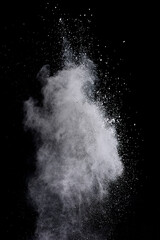 Freeze motion of white color powder exploding on dark background.