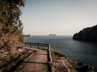 Fototapeta premium Bay at sunset, pedestrian road with sea view.