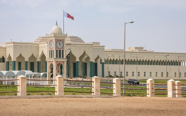 Qatar national flag flying over Amiri Diwan Parliament Building and clock tower