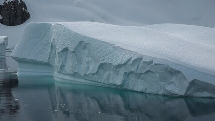 Icebergs. Moving Ice Floes and Ice Sheets in the calm Antarctic Sea, Reflection of Antarctica Mountain in water surface. © Oleksandr Umanskyi
