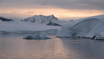 Icebergs and glaciers in Antarctica. Beautiful blue iceberg with mirror reflection floats in open ocean. Global Climate changes video - the glaciers are warming and melting faster.