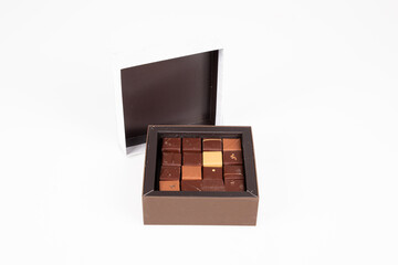 brown variety square fine artisanal chocolate pralines candy in open box on white background