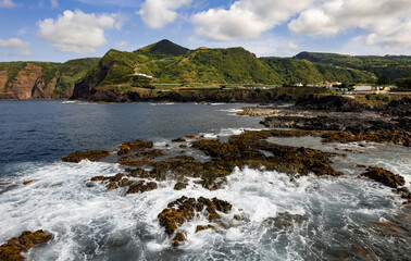 Sea waving near green mountains