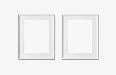 Picture frame mockup. Set of two vertical white frames on white wall background. Empty, blank...