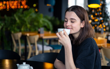 Portrait of a young woman with a cup of tea in a cafe.