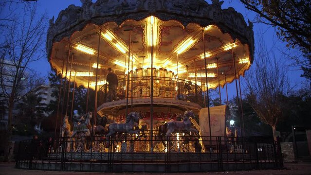 Illuminated carousel at night in an amusement park slow motion 4k