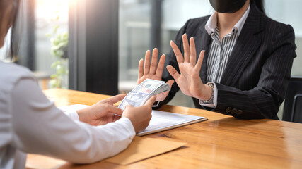 Authorities raising his hand refusing to accept bribes from customer.