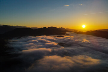 Fototapeta na wymiar Aerial panoramic view of sunrise above the clouds in the Mountains of the Alps