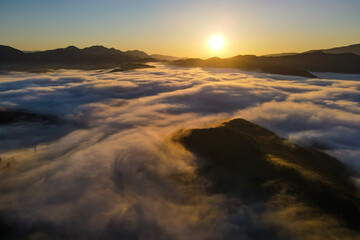 Fototapeta na wymiar Aerial panoramic view of sunrise above the clouds in the Mountains of the Alps