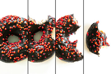 Creative concept of biting eating delicious sweet sugar black doughnut donut with red glaze on...