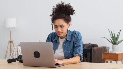 Happy excited african american woman freelancer or entrepreneur celebration success looking at digital screen laptop computer sitting at home or modern office Portrait Young female of overjoyed online