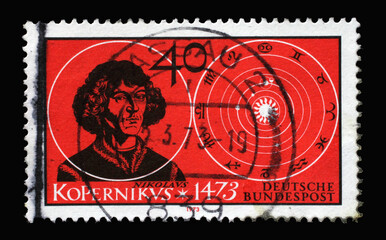 A stamp printed in Germany showing a portrait of the astronomer and doctor and mathematician Nicolaus Copernicus and his solar system, 500th Birth Anniversary of Copernicus, circa 1973.