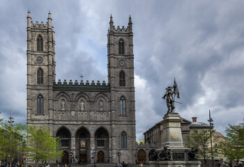 Architectural detail of the Place d'Armes in Montreal, Canada, with the Notre-Dame Basilica in the background and in the foreground the monument of Paul de Chomedey, founder of the city