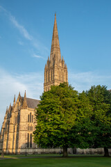 Obraz premium The spire of Salisbury Cathedral, Wiltshire, against a clear blue sky at golden hour. July 2021