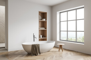 Fototapeta na wymiar Bright bathroom interior with bathtub, panoramic window with countryside view
