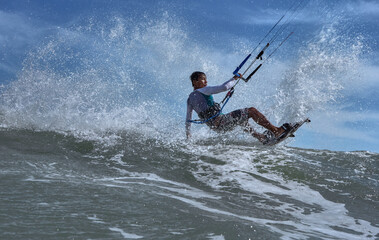 Fototapeta premium Vietnamese kite surfer jumps with kiteboard in transition