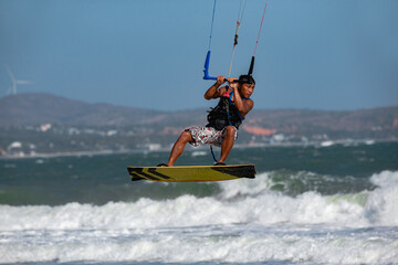 Vietnamese kite surfer jumps with kiteboard in transition