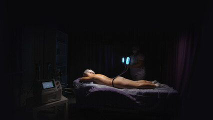 Obraz premium Woman getting cryolipolysis anti-fat anti-cellulite freezing treatment procedure in spa salon. Hardware cosmetology. Wellness body and skin care, beauty treatment, receiving rejuvenation procedure