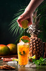 Summer cocktail with vodka, pineapple juice, mango, ice. Long drink or cold mocktail. Bartender...