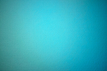 Photo of the texture of a soft blue fabric. Beautiful blue background for text. Felt texture of sea color.