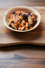 Mix fruit and nut mix in a small wooden cup. Healthy choice for energy. Raisins, walnut, almond in a bowl. Nature product