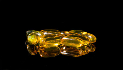 Close up of Omega 3 gel capsule on a reflective black background