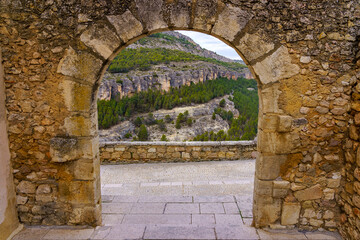 Medieval stone arch with views of the rocky mountain, in the city of Cuenca, Spain.