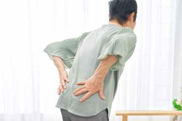 腰が痛い高齢女性　リビング
