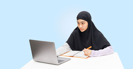 A Muslim girl uses a laptop caomputer for online learning.
