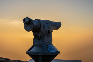 coin operated telescope at sunset 
