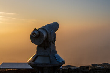 coin operated telescope at sunset 