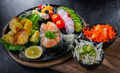 Fried salmon with potatoes and vegetable salads