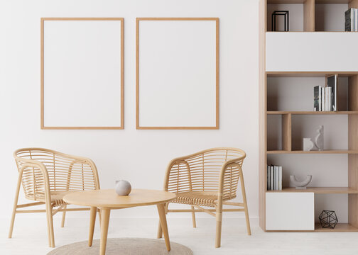 Two empty vertical picture frames on white wall in modern living room. Mock up interior in scandinavian, boho style. Free space for picture, poster. Rattan armchairs, table, shelves. 3D rendering.