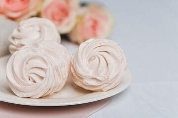 A juicy white marshmallow lies on the table. Delicious dessert for tea.