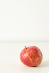 yellow and red apple on white table