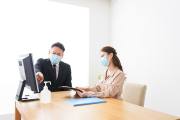 感染症対策をしてオフィスで働くビジネスパーソン