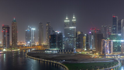 Fototapeta na wymiar Cityscape of skyscrapers in Dubai Business Bay with water canal aerial all night timelapse