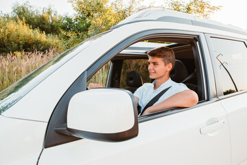 young handsome confident man driving car