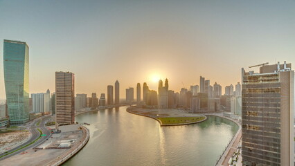 Fototapeta na wymiar Sunset cityscape of skyscrapers in Dubai Business Bay with water canal aerial timelapse