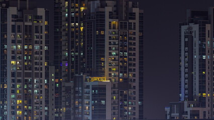 Skyscrapers with glowing windows night timelapse.