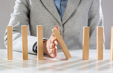 Business woman hand stop domino effect