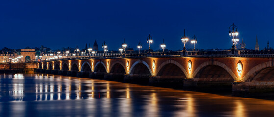 Panoramic view of stone bridge by night in Bordeaux