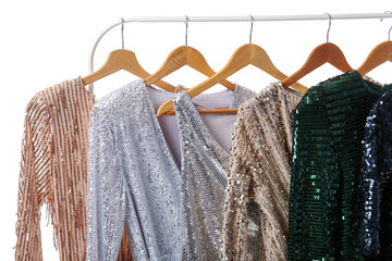 Rack with different trendy dresses on white background, closeup