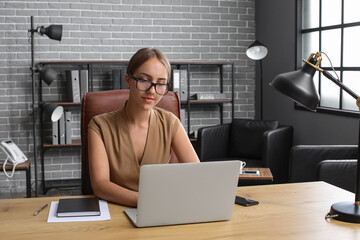 Young businesswoman working with laptop at table in office