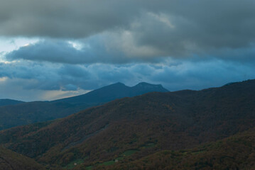Fototapeta na wymiar Mountainous landscape with a cloudy sunset sky